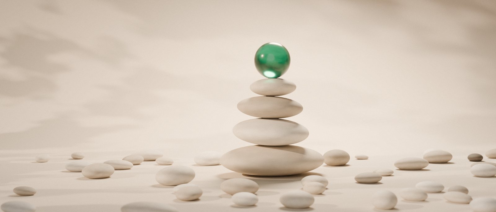 Three flat stones balanced in a cairn, with an emerald glass sphere resting on top.